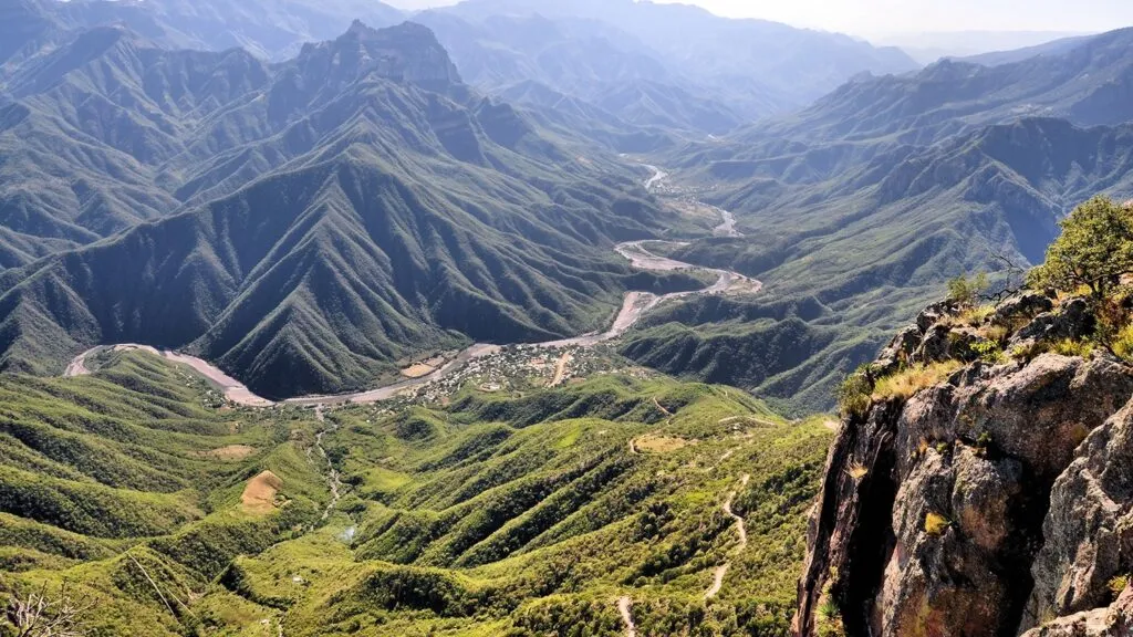 Vista panorámica de las Barrancas del Cobre en Chihuahua con montañas, ríos y comunidades en el fondo, uno de los destinos que generan mayor derrama económica turística en el estado.