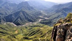 Vista panorámica de las Barrancas del Cobre en Chihuahua con montañas, ríos y comunidades en el fondo, uno de los destinos que generan mayor derrama económica turística en el estado.
