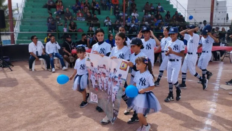 Jugadores infantiles desfilan en inauguración de Liga de Beisbol Infantil Niños Héroes en Ciudad Juárez con familias presentes.