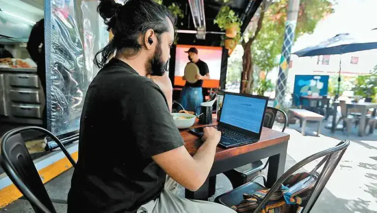 personas trabajando desde casa, haciendo home office mientras el partido esta en el fondo