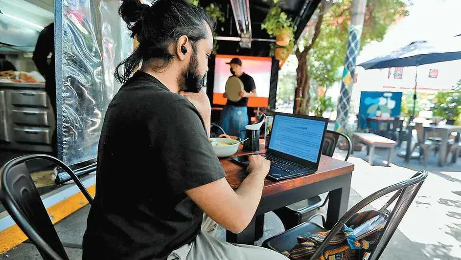 personas trabajando desde casa, haciendo home office mientras el partido esta en el fondo