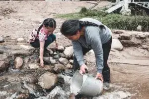 Una llave de agua casi sin flujo frente a un campo agrícola de gran extensión en Chihuahua.