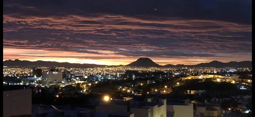 Un cielo estrellado sobre las dunas de Samalayuca, con la silueta del desierto en primer plano.