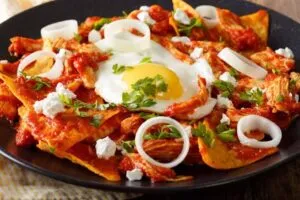 Chilaquiles mexicanos con salsa, queso y crema, un desayuno tradicional popular en Chihuahua.