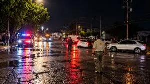 Personal de emergencia atiende incidentes en una calle mojada después de fuertes lluvias
